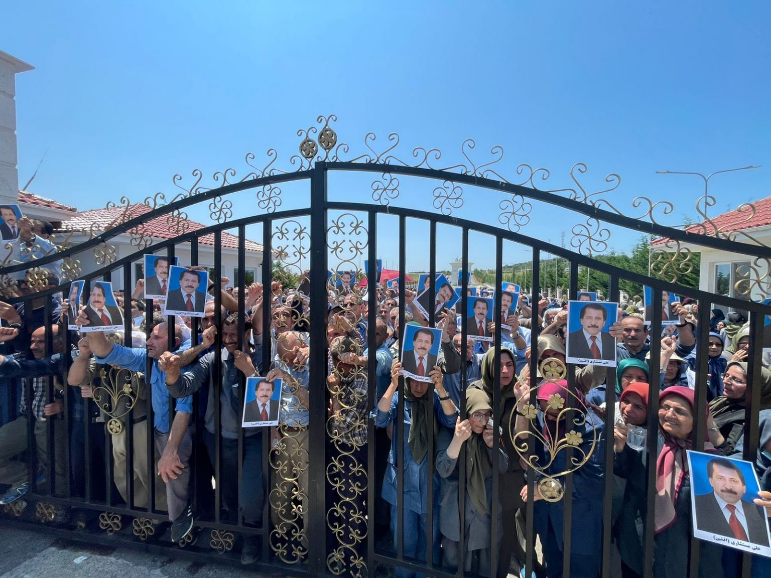 Les moudjahidines du peuple iranien du camp d'Achraf brandissent le portrait d'Ali Mostashari, mort dans les affrontements avec la police